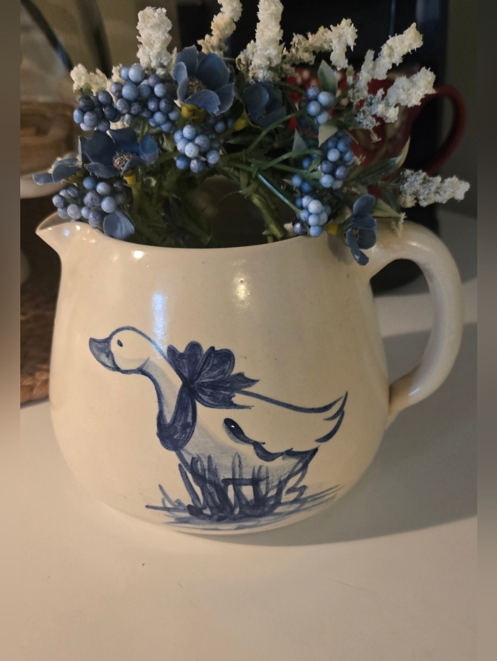 Stoneware pottery pitcher with hand-painted blue goose design